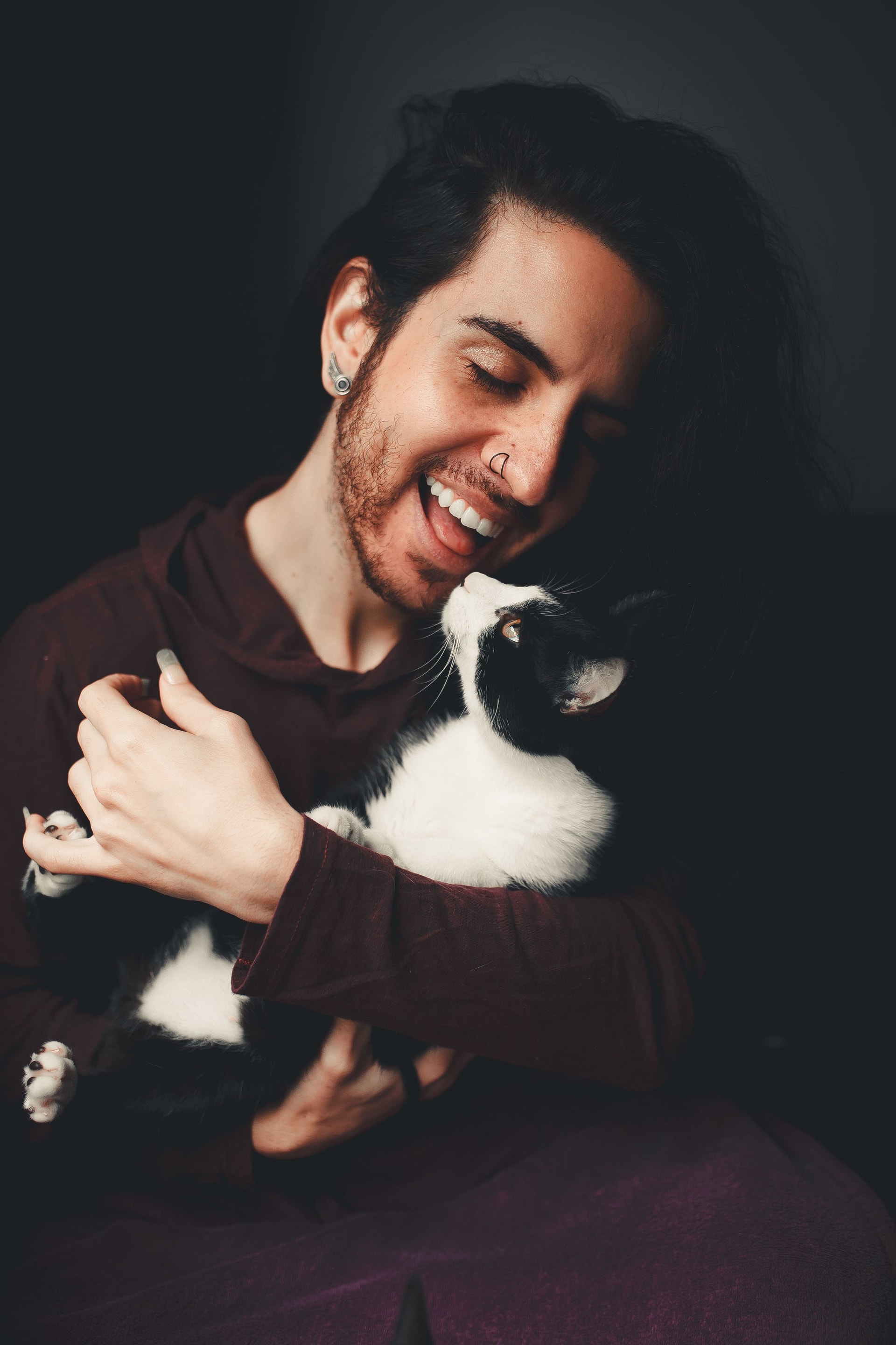 Un propriétaire souriant serre son chat contre lui